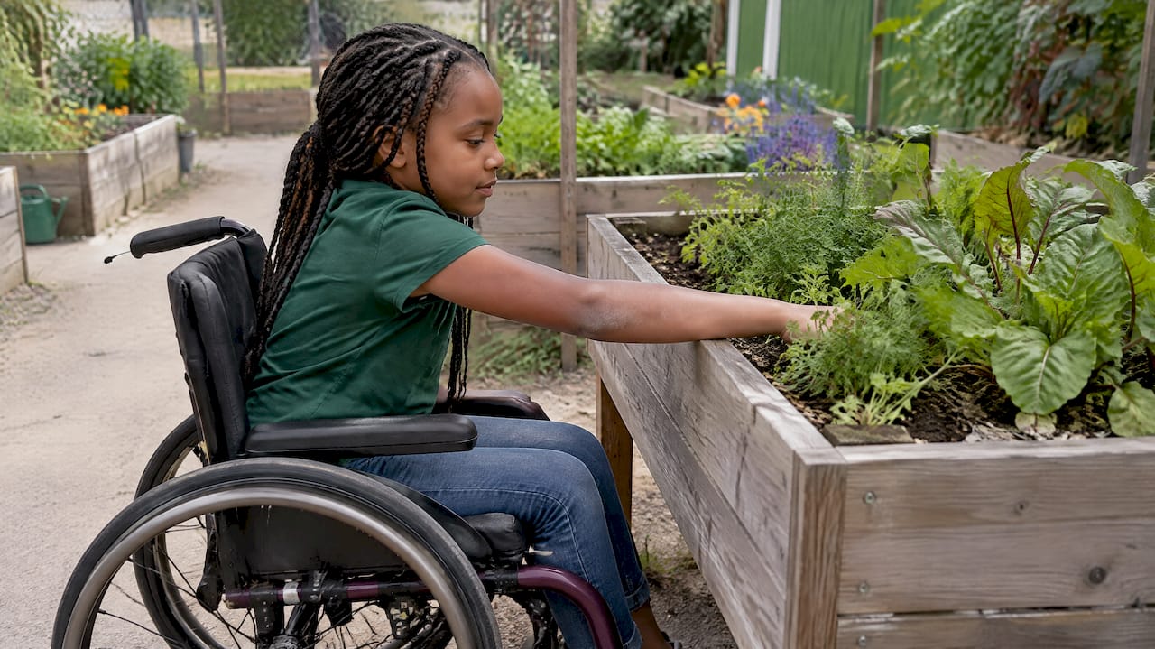 Student gardening at an accessible raised planter